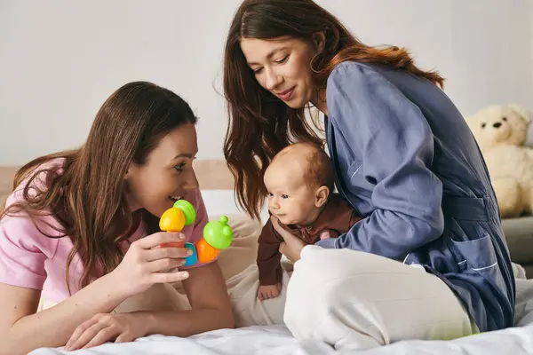 Due madri amorevoli condividono momenti speciali con il loro bambino, creando ricordi duraturi insieme. — Foto stock