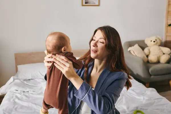 A joyful moment unfolds as a mother lifts her child in a cozy home environment on Mothers Day. — Stock Photo