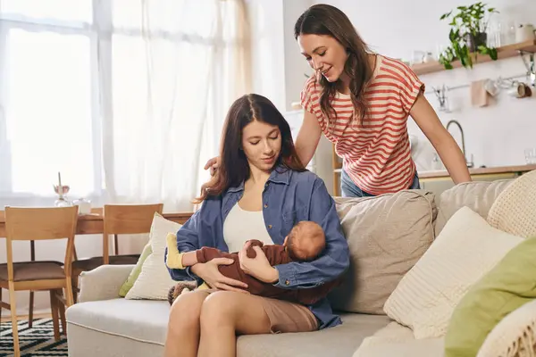 A warm moment unfolds as a lesbian couple cherishes their newborn child on Mothers Day at home. — Stock Photo
