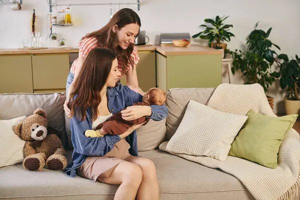 Two loving mothers embrace their baby, cherishing the joy of family togetherness. — Stock Photo