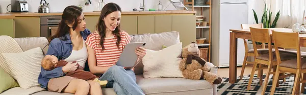 Two joyful mothers share a tender moment with their child while enjoying Mothers Day at home — Stock Photo