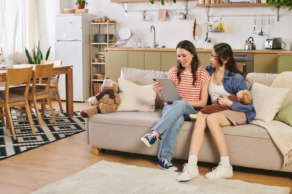 Two loving mothers enjoy quality time with their child at home on Mothers Day in a cozy setting. — Stock Photo