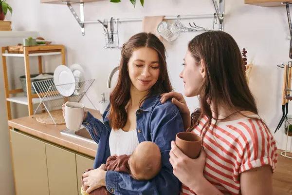 Two loving mothers celebrate Mothers Day with their child in a cozy kitchen. — Stock Photo