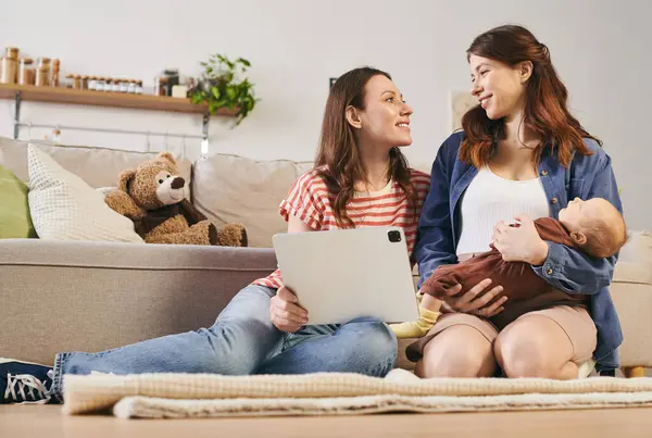 Two loving mothers celebrate Mothers Day at home with laughter and joy with their child. — Stock Photo