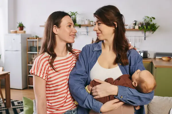 Dos madres cariñosas disfrutan de un momento especial del Día de las Madres con su hijo, irradiando alegría y calidez. - foto de stock