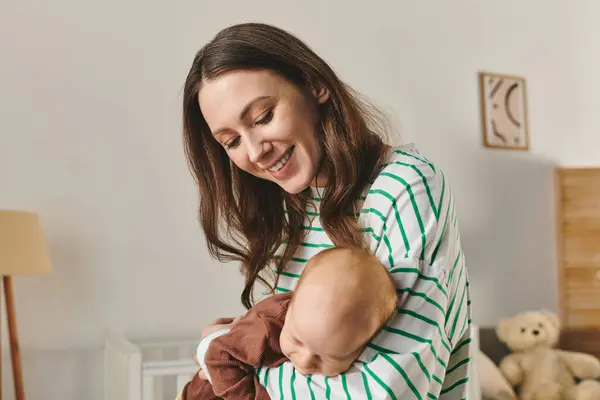 Young woman shares a heartwarming moment with her child in a warm, inviting home. — Stock Photo