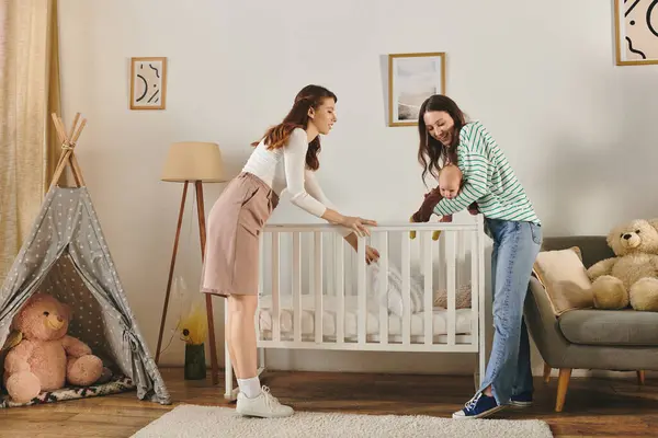 Two loving mothers share a tender moment with their child in a warm, inviting living space. — Stock Photo