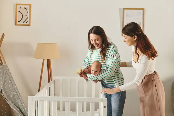 Zwei liebevolle Mütter genießen einen zärtlichen Moment mit ihrem Baby in gemütlicher Wohnzimmeratmosphäre. — Stockfoto