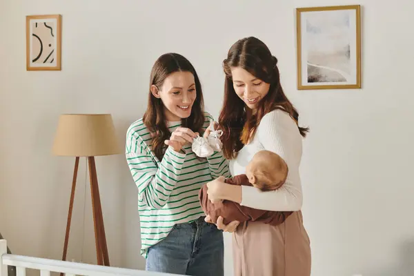Two loving mothers enjoy a joyful moment with their child in a cozy home setting. — Stock Photo