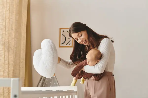 A mother cares for her child in a warm and inviting nursery, celebrating the joy of motherhood. — Stock Photo