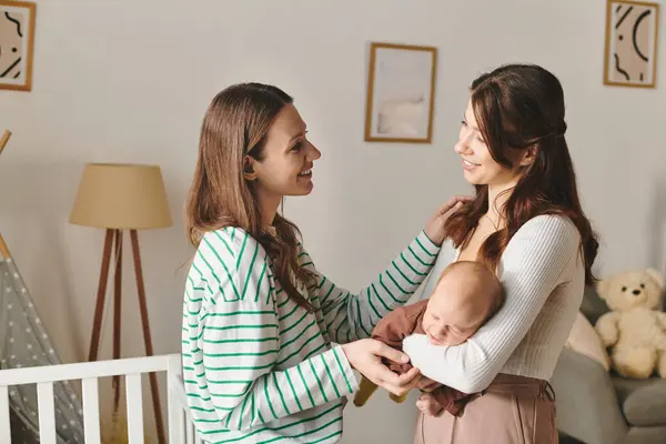Zwei Mütter teilen einen zärtlichen Moment in ihrem gemütlichen Zuhause und feiern Liebe und Familie am Muttertag. — Stockfoto