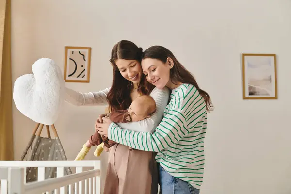 Two joyful mothers embrace their baby in a nurturing atmosphere filled with love and warmth. — Stock Photo