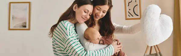 Dos mujeres alegres abrazan a su hijo mientras celebran un día de madres sinceras en casa. - foto de stock