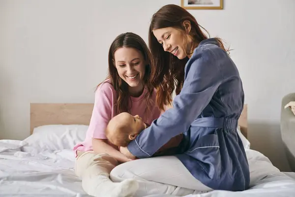 Zwei liebevolle Mütter teilen einen herzlichen Moment am Muttertag in ihrem gemütlichen Zuhause — Stockfoto