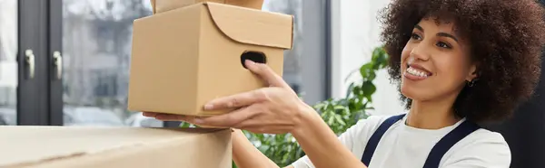 Woman joyfully unpacks boxes in a bright modern space, embracing the excitement of moving day. — Stock Photo