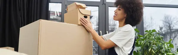 Uma mulher empilha caixas de papelão em um quarto moderno, pronto para realocação. — Fotografia de Stock