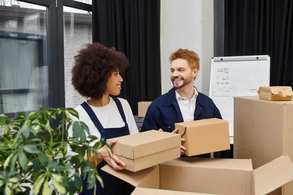 Two individuals are actively engaged in packing and unpacking boxes, creating a lively atmosphere. — Stock Photo