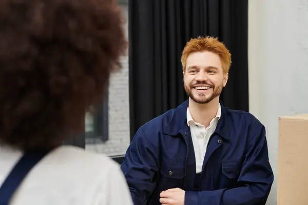 Dois indivíduos compartilham um momento alegre enquanto discutem planos em movimento em um ambiente moderno. — Fotografia de Stock