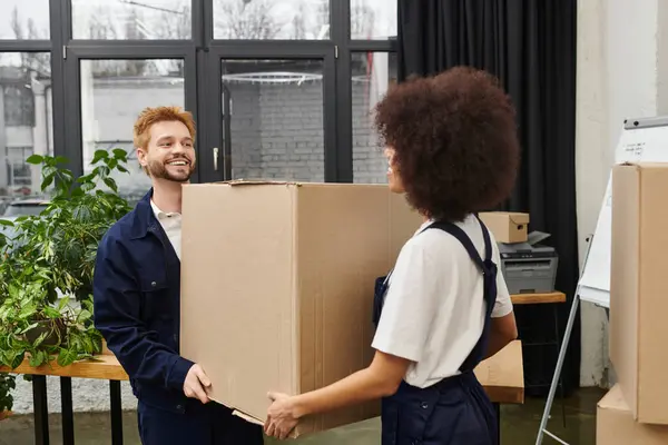 Two people joyfully pack and unpack boxes in a modern setting, highlighting the thrill of moving. — Stock Photo