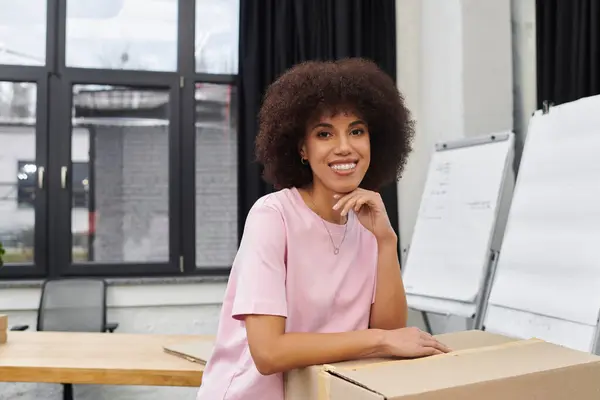 A cheerful woman packs and unpacks boxes in a modern setting. — Stock Photo