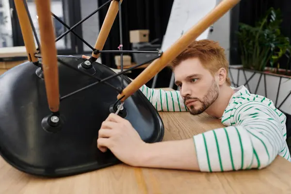 Focusing intently on securing furniture components while unpacking in a contemporary setting. — Stock Photo