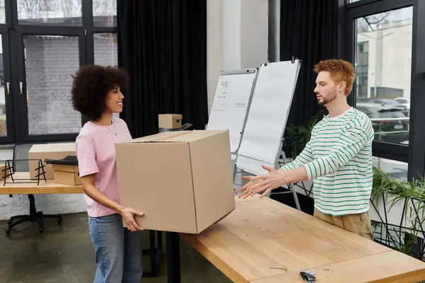 Zwei Personen packen Kartons und machen sich bereit, in einem modernen Büroumfeld zu ziehen. — Stockfoto