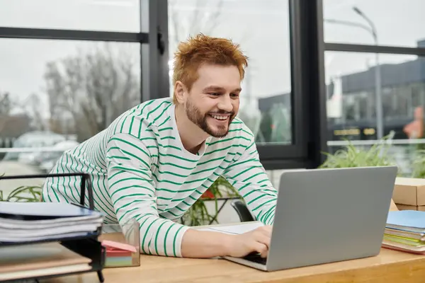 A cheerful man organizes tasks for his move on his laptop in a modern office. — Stock Photo