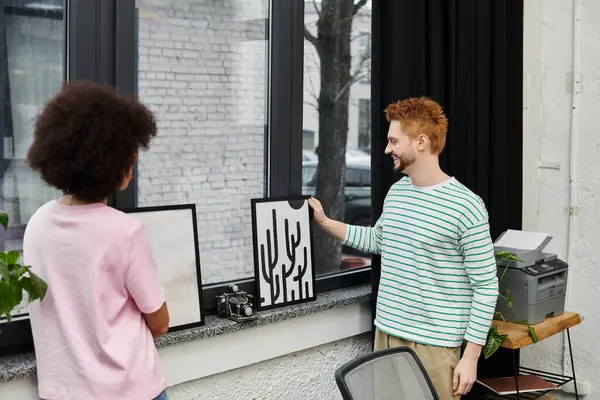 Dos personas discuten el arte por una ventana, añadiendo energía mientras se preparan para moverse. - foto de stock