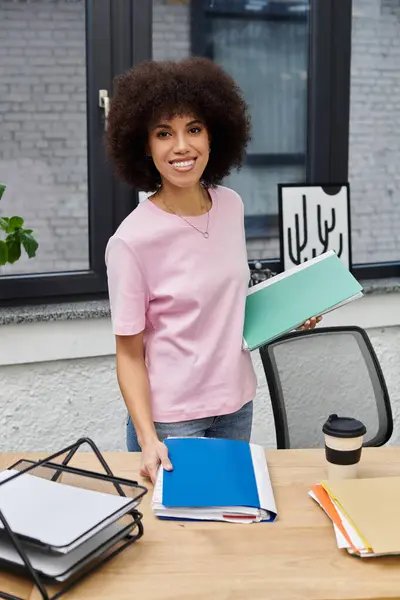 A young woman organizes her essentials while packing and unpacking in a modern office. — Stock Photo