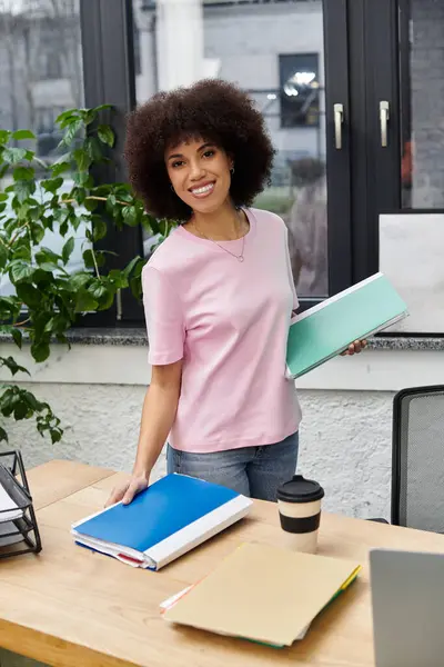 A woman cheerfully organizes and sorts through office supplies while moving into a new workspace. — Stock Photo