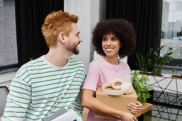 Um casal feliz embala e desempacota em seu apartamento moderno cheio de plantas. — Fotografia de Stock
