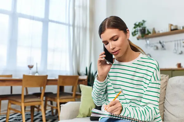 Яскравий і привабливий житловий простір має молоду жінку, яка говорить по телефону і робить нотатки. — стокове фото