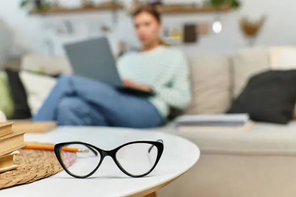 A young woman deep in thought works on her laptop in a stylish, cozy setting. — Stock Photo