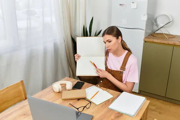 Bright and modern atmosphere as a young woman focuses on her creative project at a wooden table. — Stock Photo