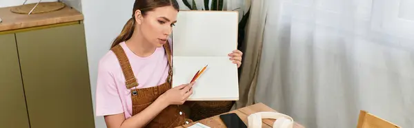 A young woman sits at a modern workspace, sketching ideas with colorful pencils. — Stock Photo