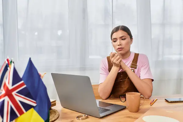 Молодая женщина учится на ноутбуке, открывая для себя знания в уютном, уютном пространстве. — стоковое фото