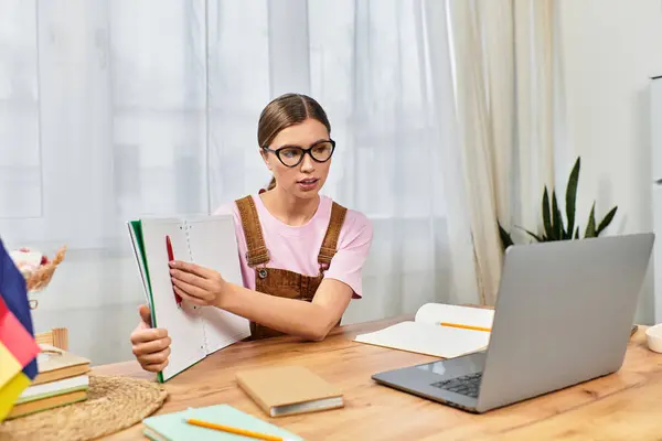 Modern woman in glasses interacts with a laptop while showcasing notes in her home office — Stock Photo