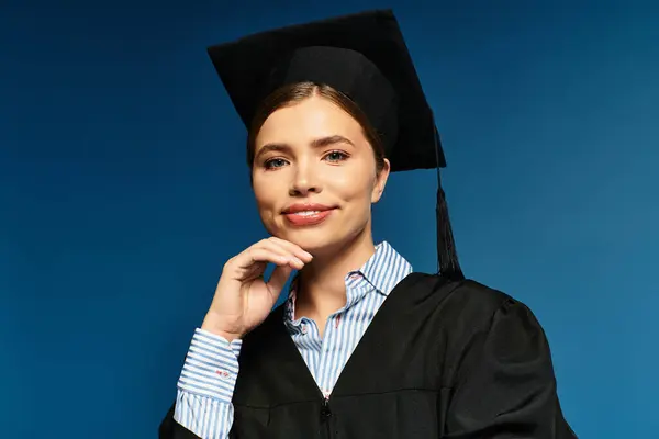 Молодая женщина в шапке и халате уверенно позирует на синем фоне, излучая радость. — стоковое фото