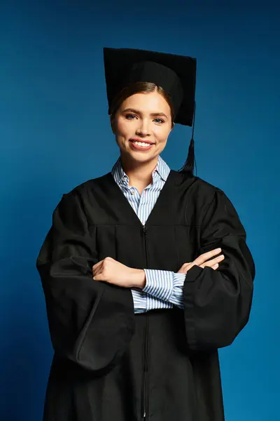 A young woman confidently celebrates her achievement in her graduation cap and gown. — Stock Photo