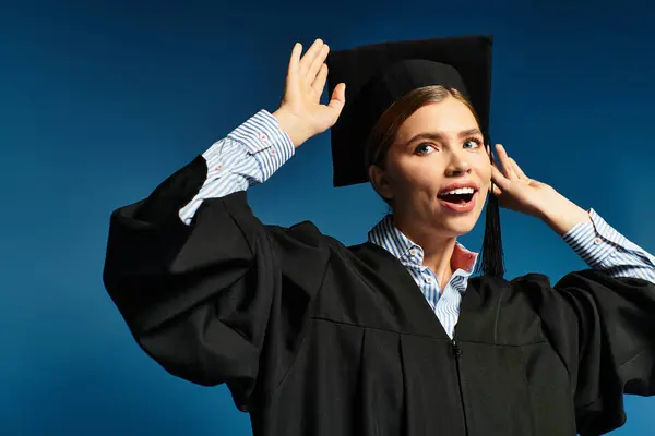 Joven hermosa mujer que lleva una gorra de graduación expresa felicidad y orgullo por su logro. - foto de stock