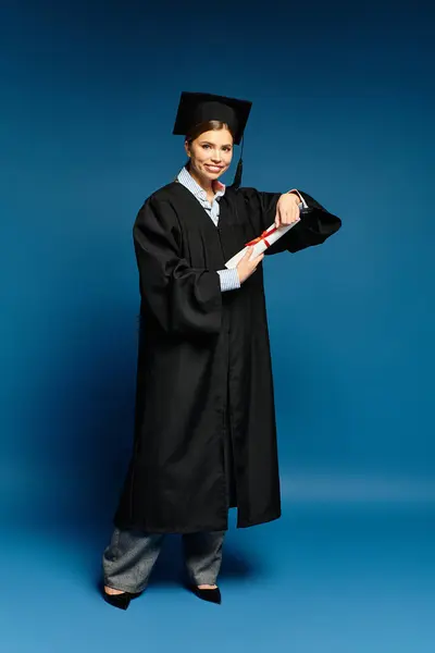 A young beautiful woman in a graduation gown holds her diploma, radiating joy and success. — Stock Photo
