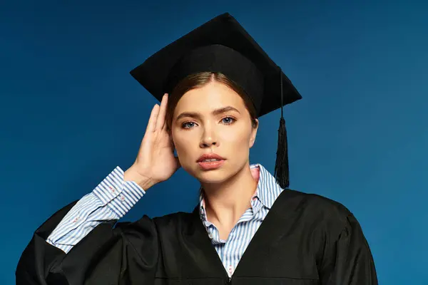 A proud young woman in a graduation cap and gown celebrates her achievements. — Stock Photo