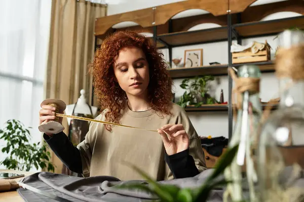 A talented craftswoman carefully measures fabric while working on her latest DIY project indoors. — Stock Photo