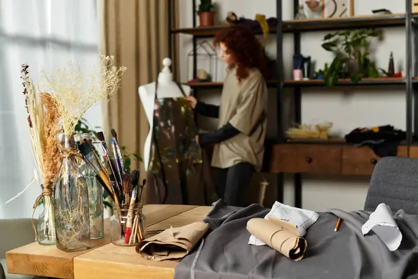 Une artisan habile conçoit dans un studio élégant rempli de fournitures artistiques. — Photo de stock