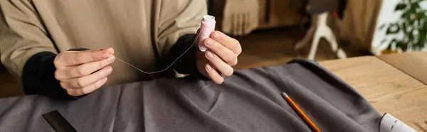 A young woman skillfully threads a needle in a cozy, inspiring crafting space. — Stock Photo