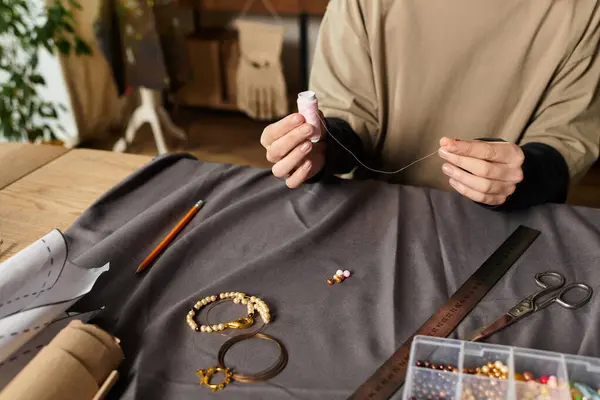 Jeune femme artisanat bijoux uniques avec du fil et des perles dans son espace de travail. — Photo de stock