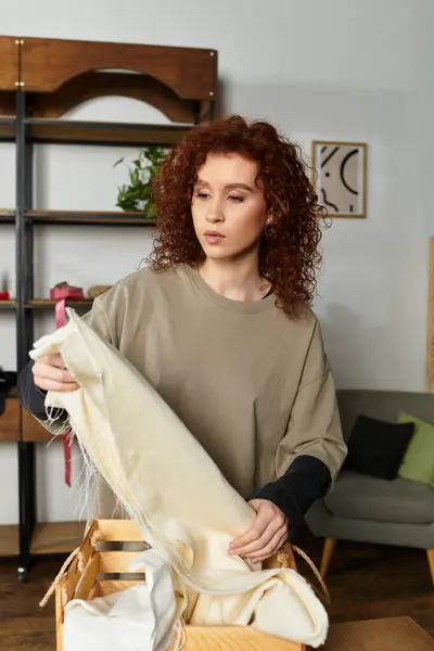 A young beautiful woman showcases her DIY talent while arranging materials in a stylish home. — Stock Photo