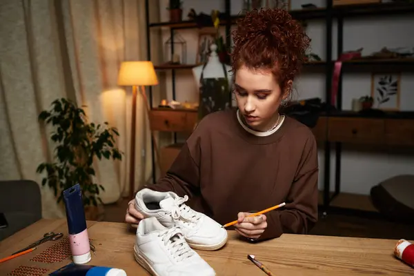 Talented young woman engages in DIY craft project, decorating shoes in her trendy home studio. — Stock Photo