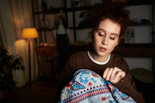 Focalisée femme méticuleusement coutures motifs colorés dans son projet de broderie bricolage la nuit. — Photo de stock