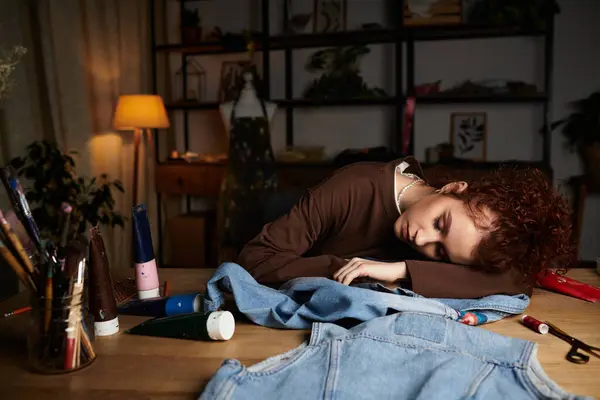 A young woman relaxes on her crafting table, surrounded by DIY materials at dusk. — Stock Photo
